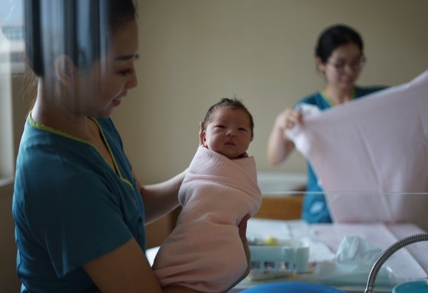 nurse holding a newborn baby