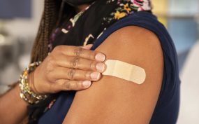 Woman touching band aid on arm