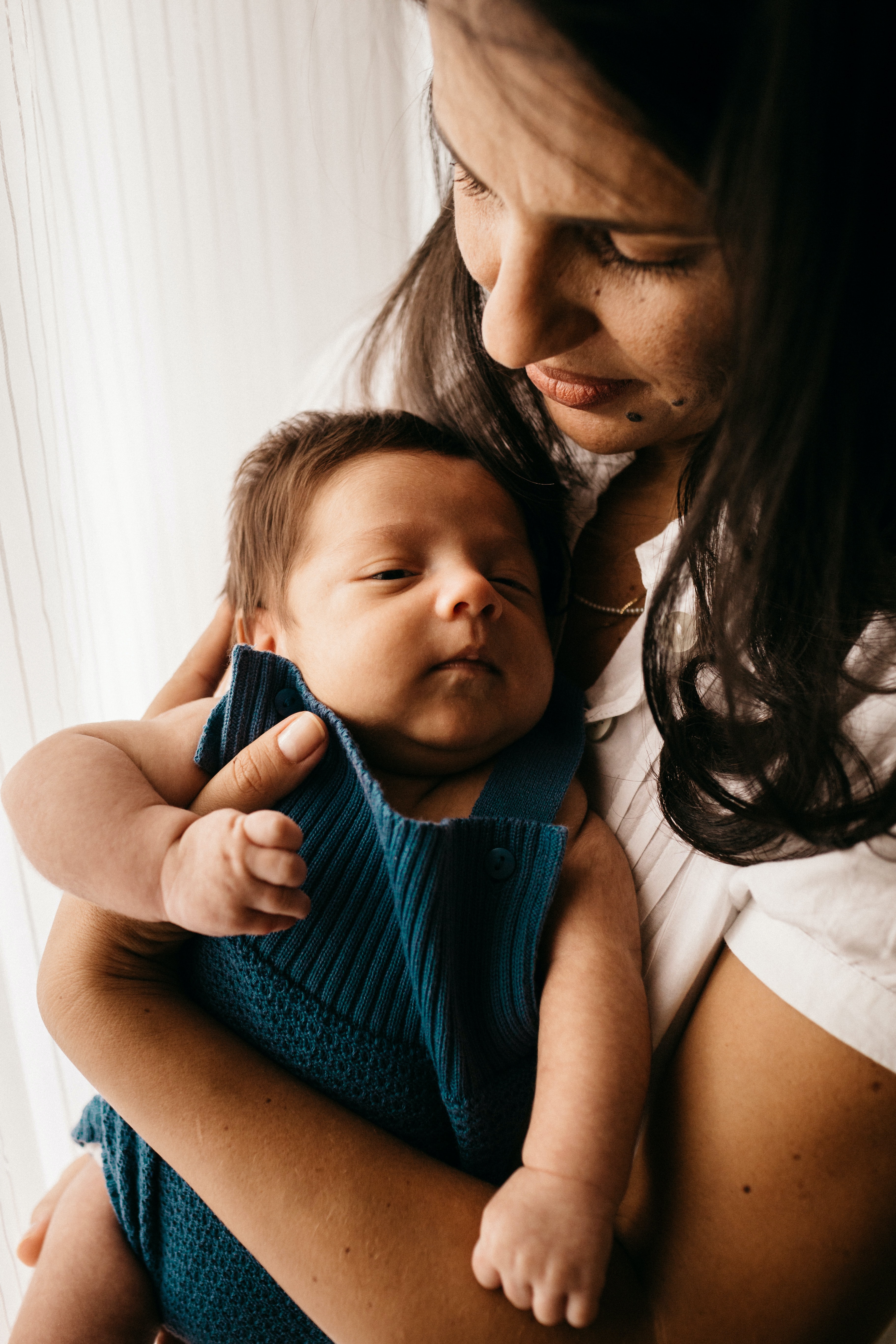 Une femme tient un bébé devant un porte-bébé