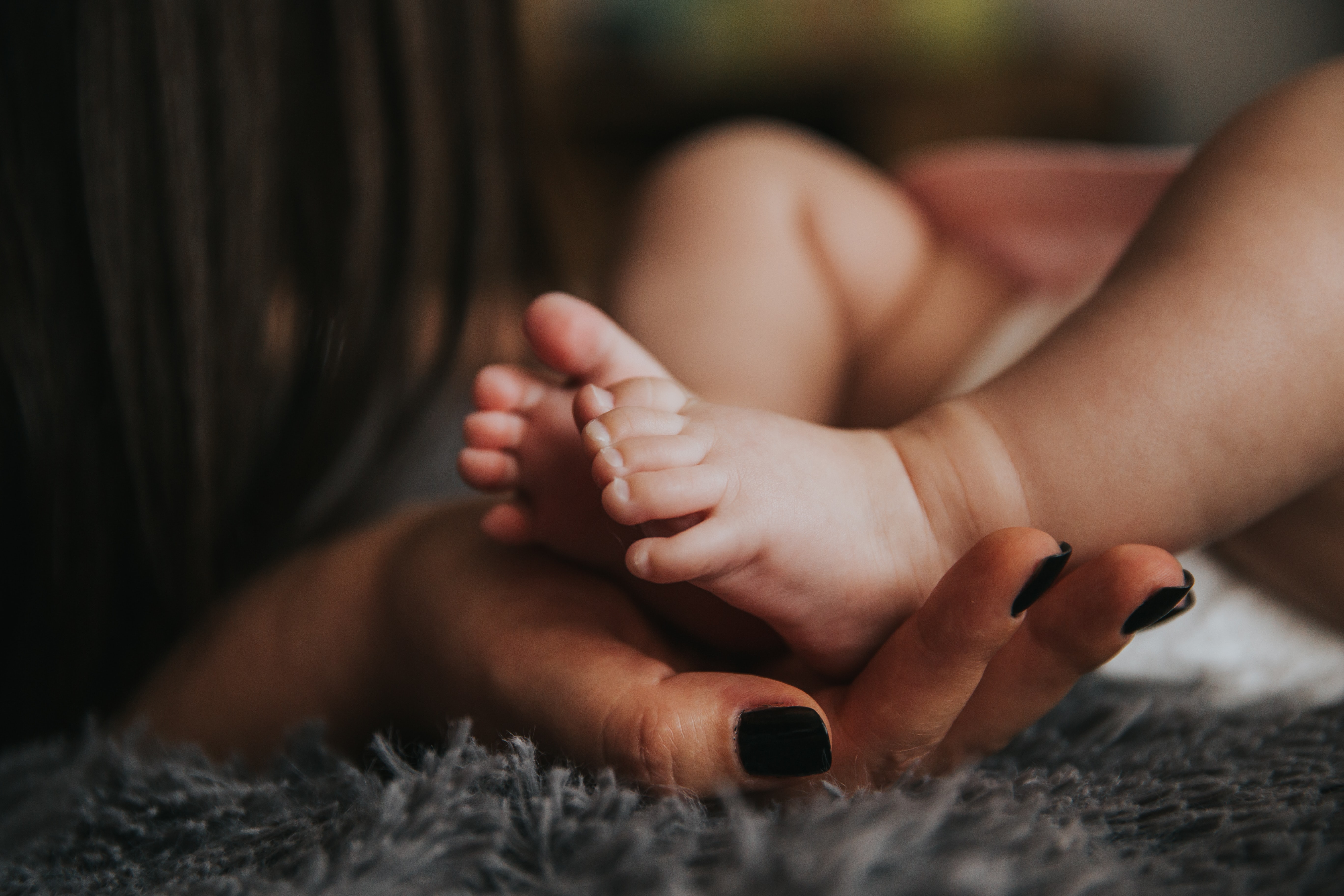hand holding tiny feet of newborn
