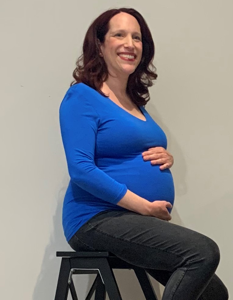 pregnant woman smiling and holding belly