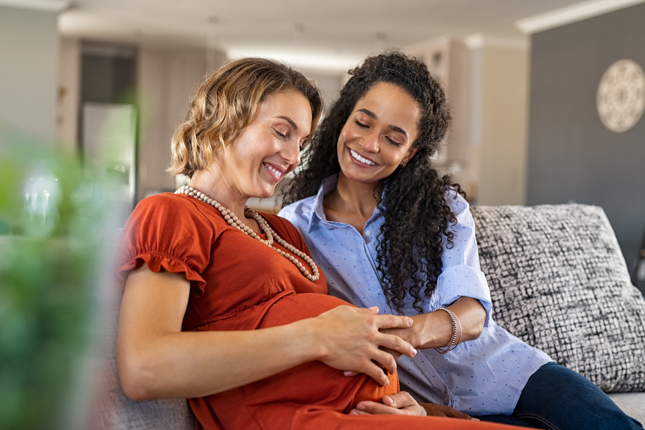 Deux femmes, l’une enceinte, sur un divan