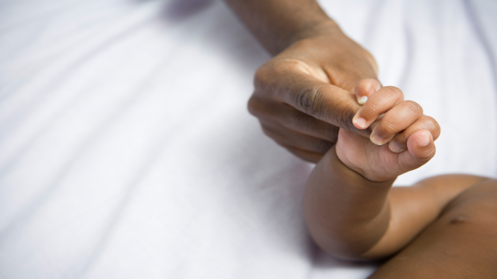 Maman et bébé se tiennent par la main (bras et mains seulement)