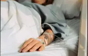 woman with IV lying in hospital bed