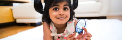 Little girl holding a glucometer